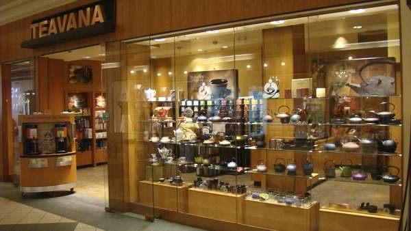 Teavana mall storefront, with glass display case of teapots, doorway, and store behind