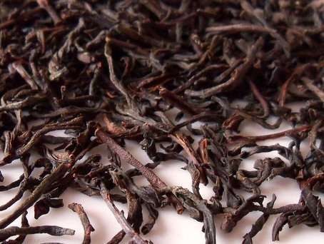Long, wiry, twiggy-looking tea leaves with black to reddish-olive colors