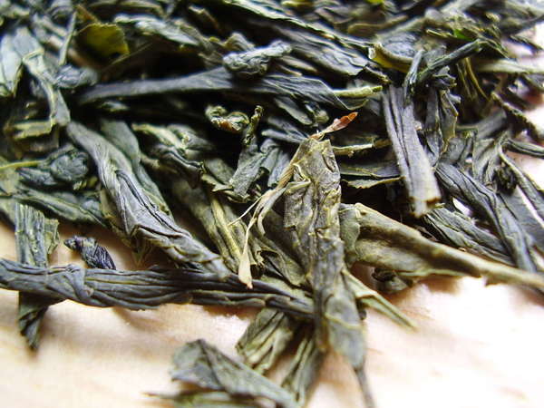 Loose-leaf green tea with large, intact, somewhat wrinkly leaves, dark gray-green with yellow-green hues